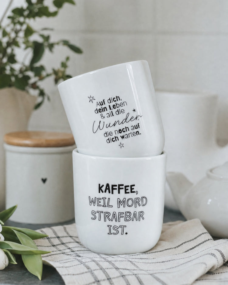 Schwarz-weißer Kaffeebecher mit langem Schriftzug