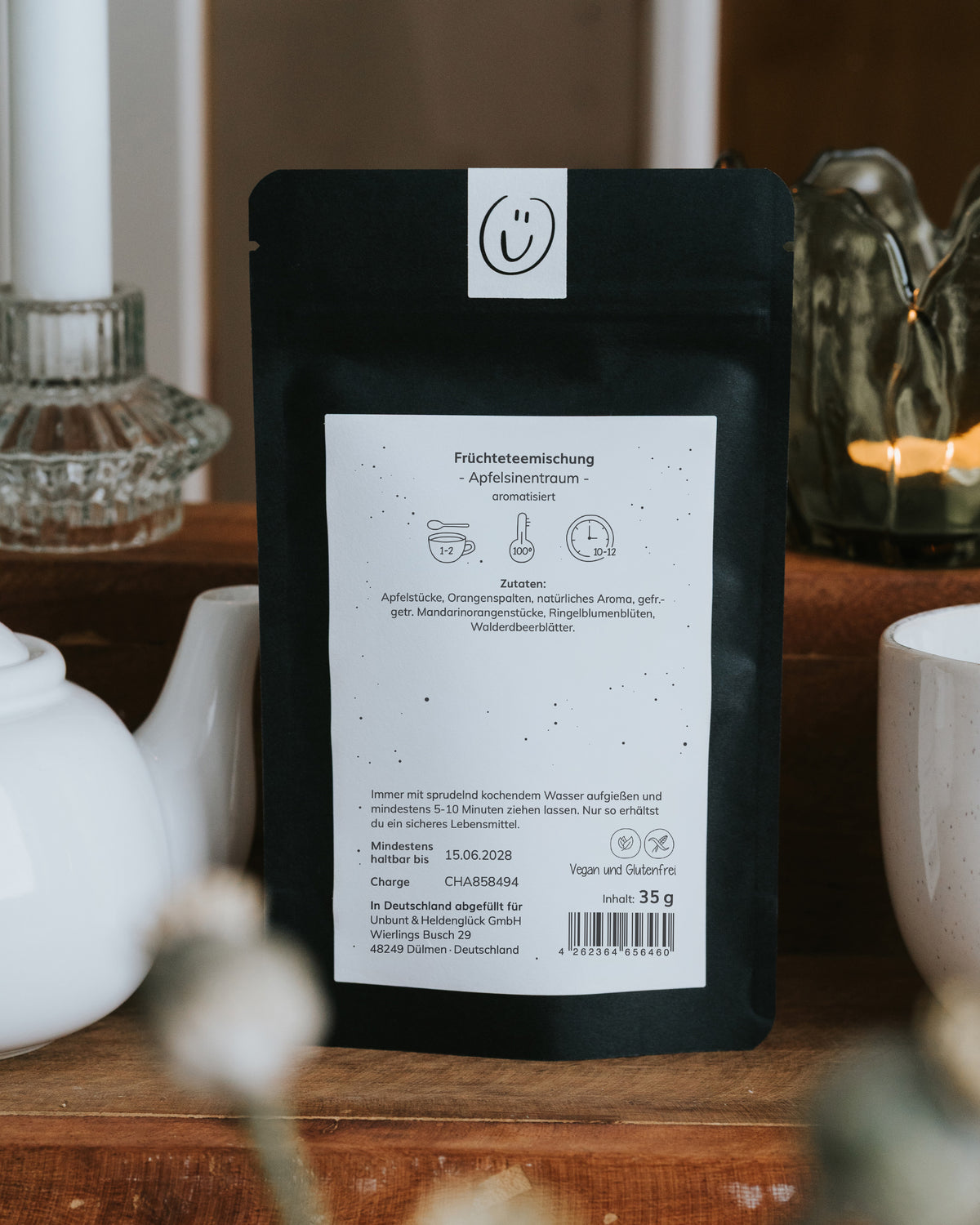 Rückseite der Verpackung mit Zutatenliste (Apfelstücke, Orangenspalten, Ringelblumenblüten), Zubereitungshinweis, Mindesthaltbarkeitsdatum 15.06.2028 und Hinweisen vegan sowie glutenfrei, Nettofüllmenge 35 g